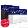 Two large aquariums with coral displays on black and white cabinets, featuring a 3-year warranty.